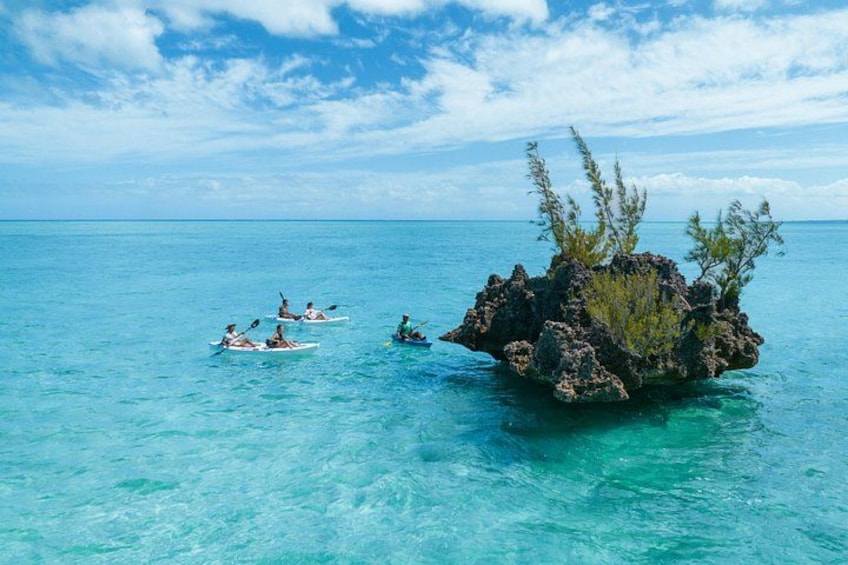 Mar azul transparente con kayaks cerca de una isla rocosa. 2