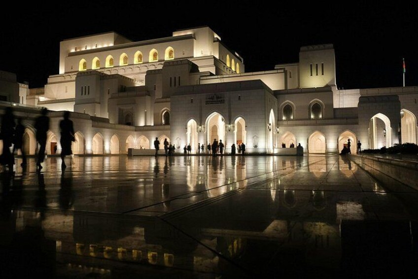 A large, illuminated building with multiple arches and a reflective courtyard. 5