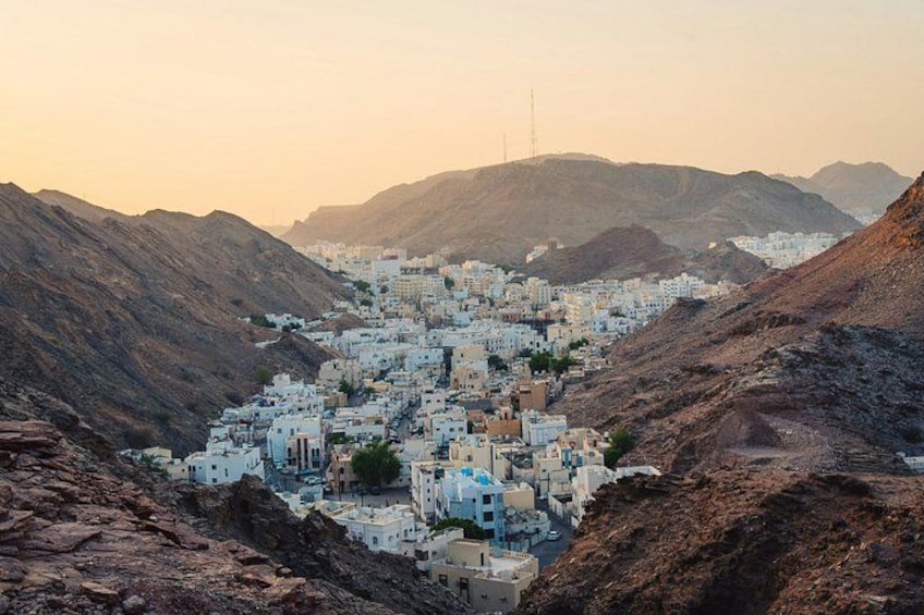 A town nestled in a valley with white buildings, surrounded by rugged hills. 4