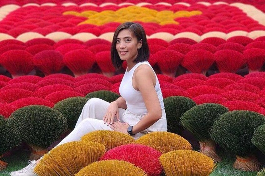 A person sitting amidst a field of colorful spherical plants. 2