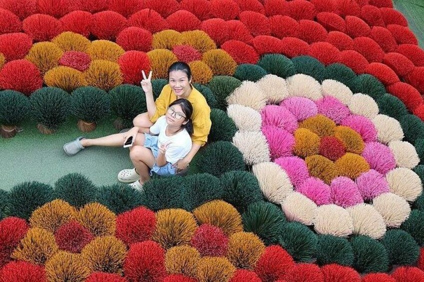 A large, colorful circular flower arrangement with people sitting in the center. 1