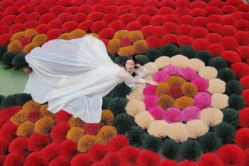 A person lying on a patterned carpet of flowers. 3