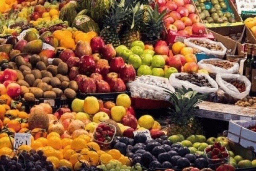 A fruit market with various fruits like apples, oranges, and pineapples. 2