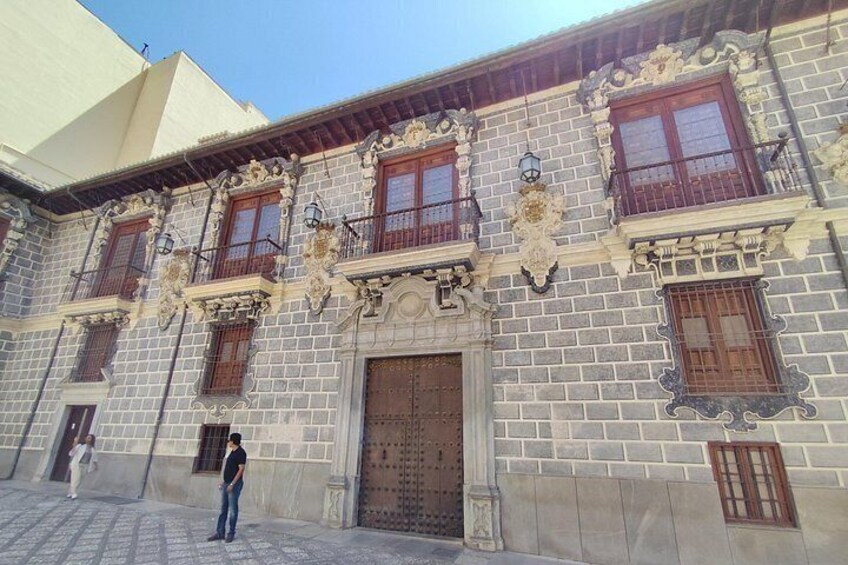 Un bâtiment historique doté d’éléments architecturaux raffinés, notamment des fenêtres décoratives et une grande porte en bois. 3