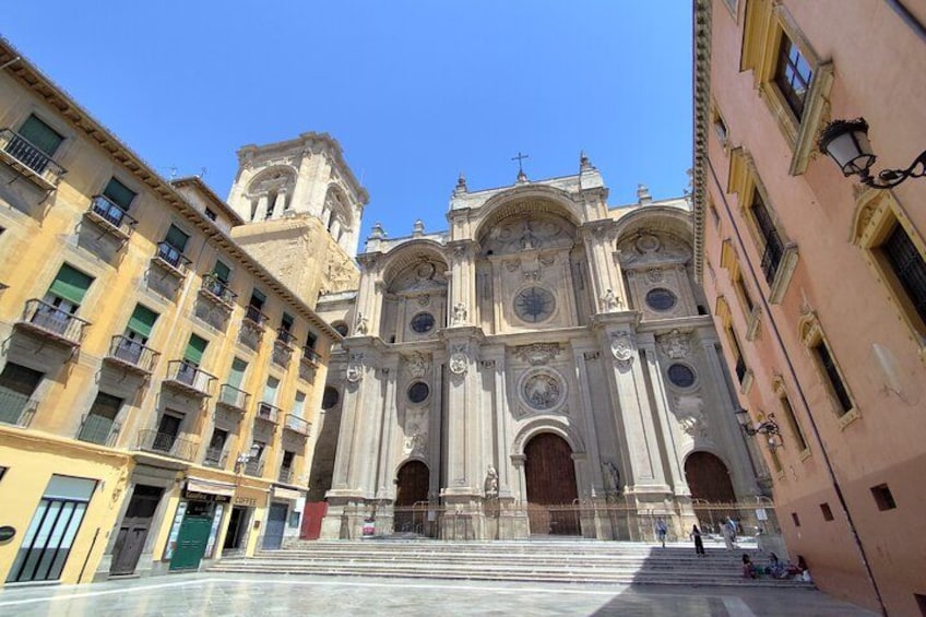 Una catedral imponente con arquitectura ornamentada, una torre de campanas y una escalera que conduce a su entrada. 1