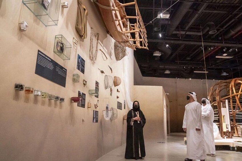 Una exhibición interior con diversos artefactos expuestos en las paredes, incluyendo joyería y objetos decorativos. 2