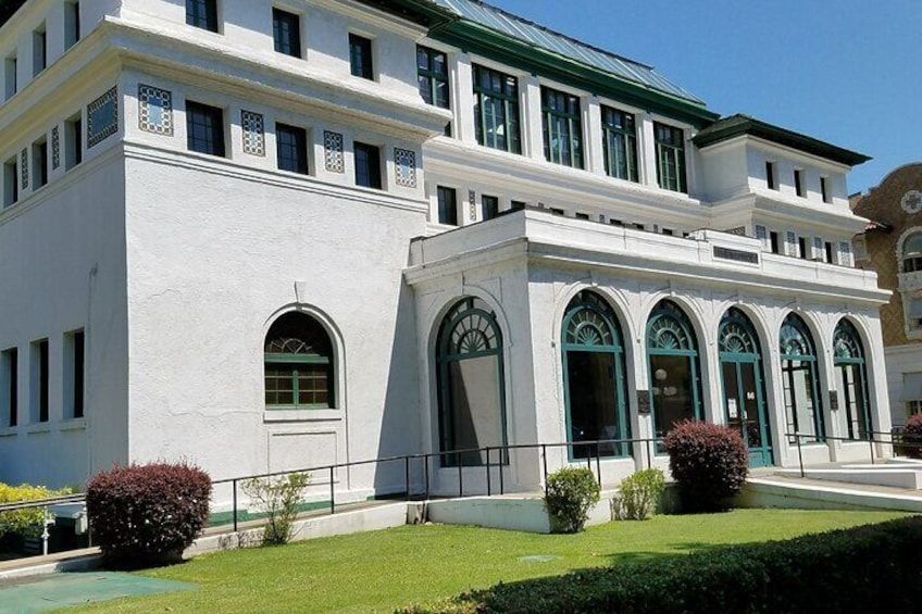 A white building with arched windows and a green roof. 5