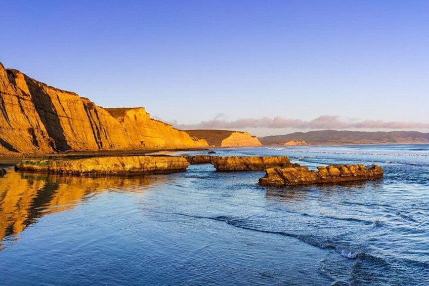 A coastal landscape with cliffs and calm sea. 5