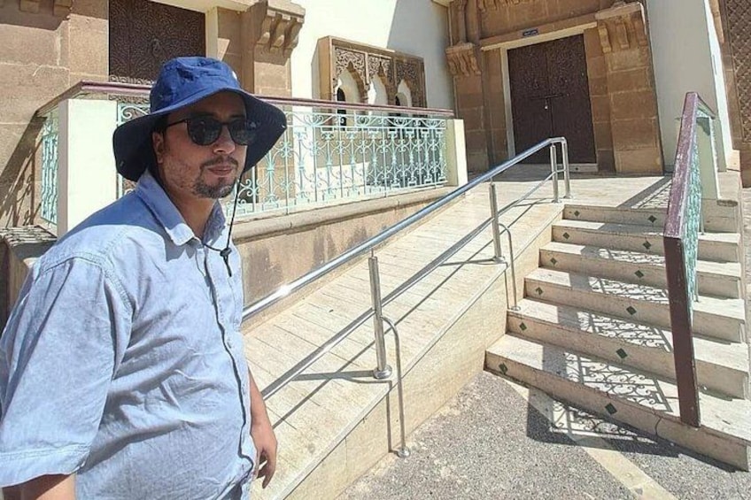 Un homme se tient à côté d’un escalier doté de rampes en métal et d’un sol à motifs. 4