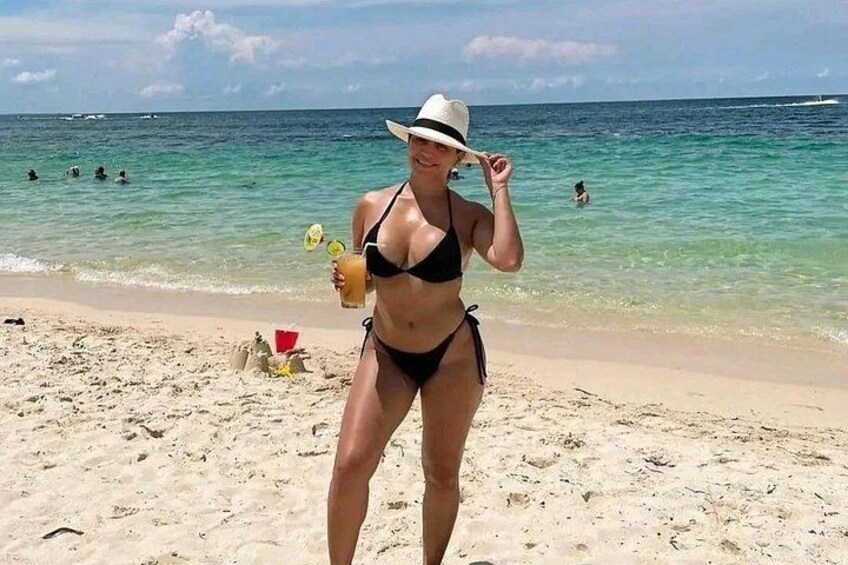 Una persona en traje de baño sobre una playa arenosa, con el océano al fondo. 2