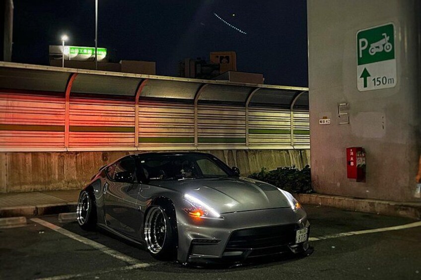Un'auto sportiva color argento parcheggiata in un parcheggio di notte. 3