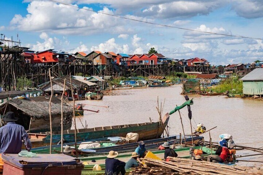 Un pueblo a orillas del río con casas de madera y barcos. 5