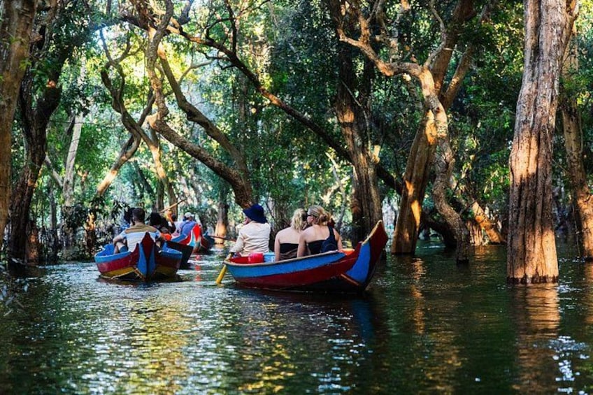 Un grupo de personas en un bote navegando por un canal rodeado de árboles. 1