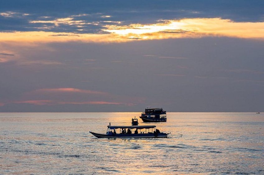 Un barco con camarote navegando sobre aguas tranquilas durante el atardecer. 4