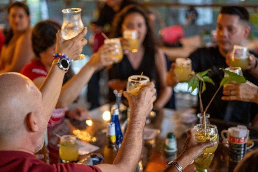 People toasting with drinks at a bar. 3