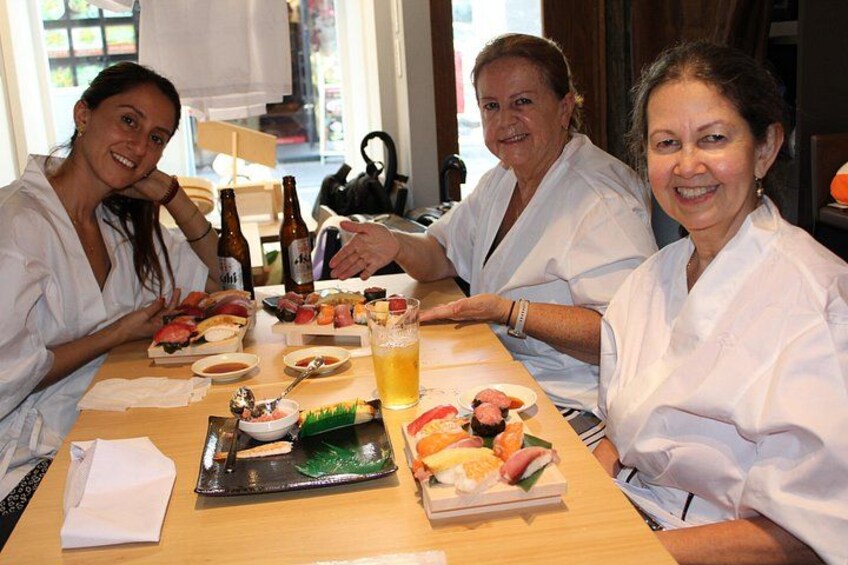 A group of people sitting at a table with various dishes and drinks. 3