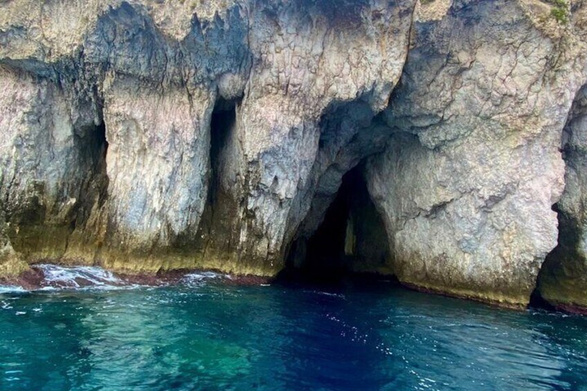 A coastal rock formation with a cave entrance. 4