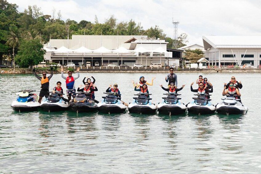 Un gruppo di persone sui jet ski in un tratto d'acqua, con edifici sullo sfondo. 5