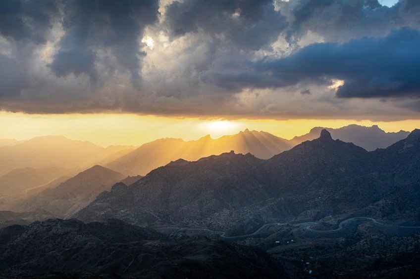 Un paysage montagneux, avec le soleil se couchant derrière les sommets. 4