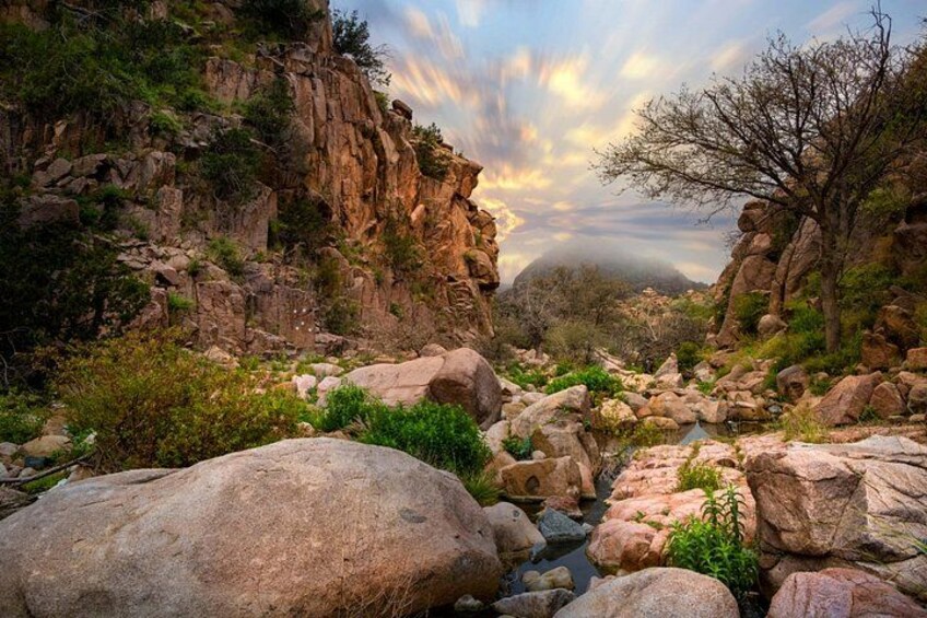 Un paysage rocheux avec un ruisseau, de gros blocs de pierre et une végétation clairsemée. 3