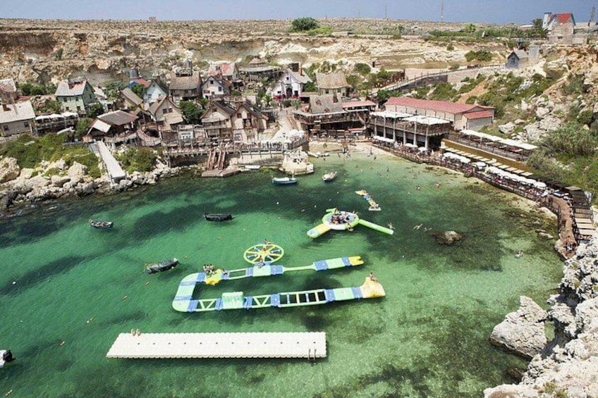 Una zona costiera con un mare cristallino, una passerella e diverse imbarcazioni. 3