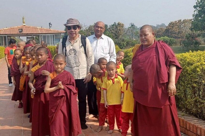 Monks and children in traditional attire standing on a pathway. 4