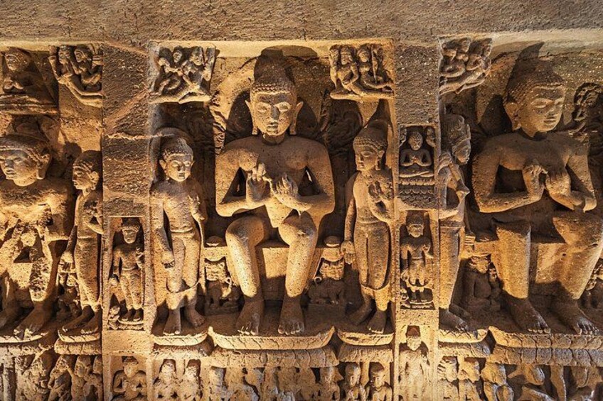 A detailed stone carving of seated figures, likely from an ancient structure. 5