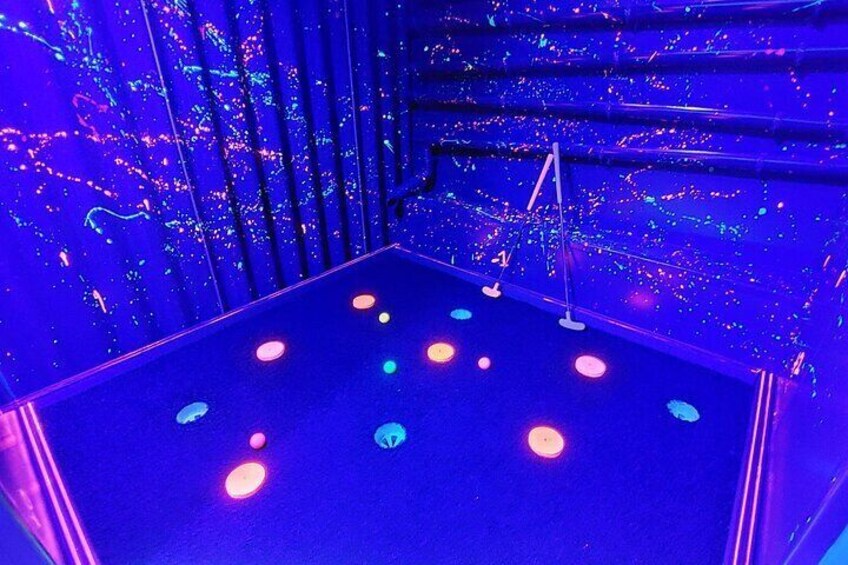 A room with a blue floor and walls, illuminated by colorful lights. 4