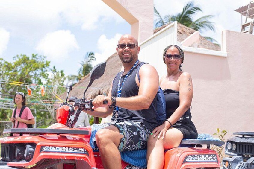 A man and a woman on a red ATV. 5