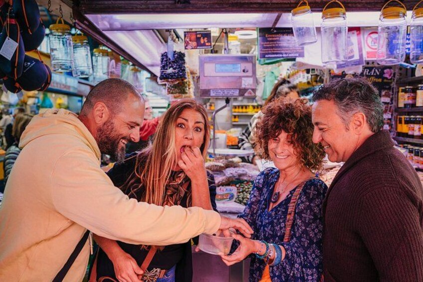 Un gruppo di persone in un mercato con diversi articoli esposti. 2