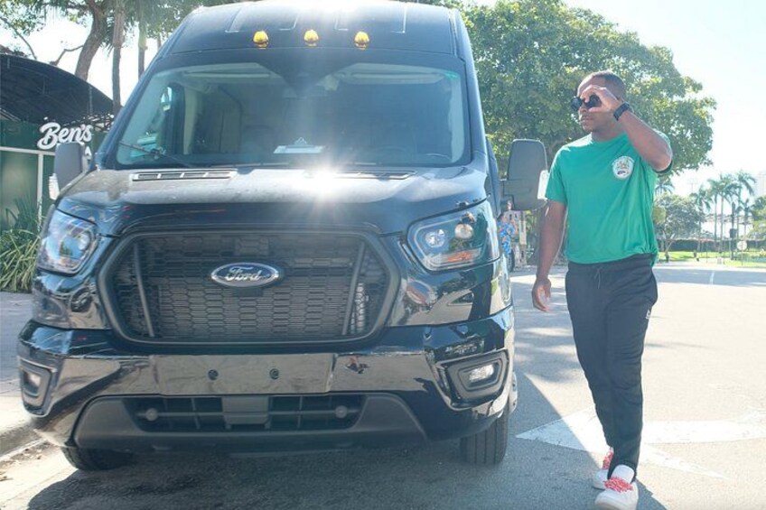 A black Ford truck parked on a street with a person walking beside it. 2