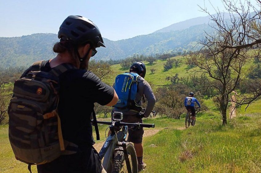 Twee fietsers op een pad, met een bergachtig landschap op de achtergrond. 5