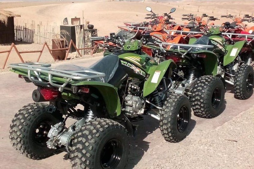 Une rangée de quads verts est stationnée sur un sol en terre battue. 5