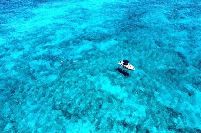 Un mare blu cristallino con una barca che galleggia sulla superficie. 3