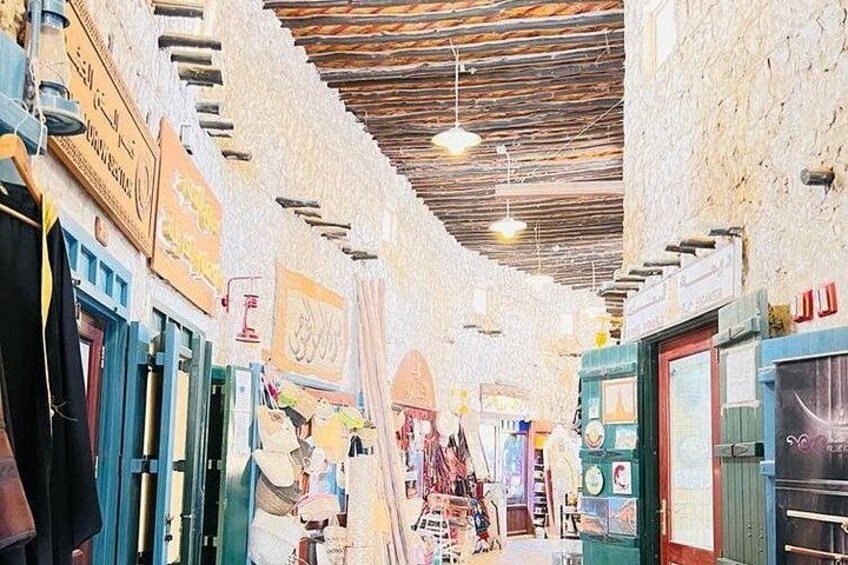 An indoor market with various stalls and signs. 2