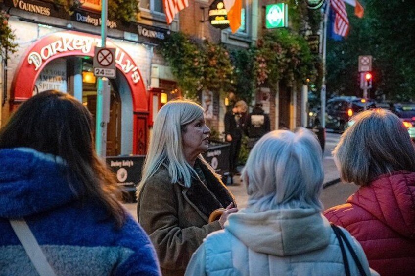 Een straatbeeld met een rode boog waarop 'Darker's Pub' staat en een groen verkeerslicht. 4