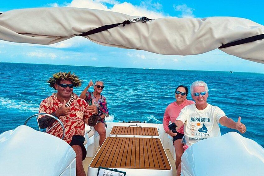 En båt med personer som bär hattar och solglasögon, ett träbord och havet i bakgrunden. 4