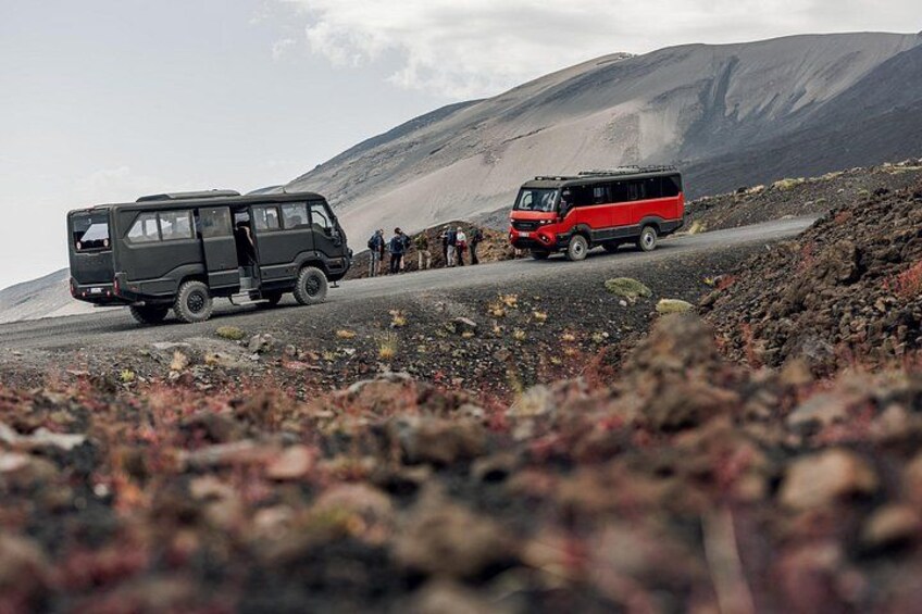 Two vehicles on a rocky terrain with a mountainous backdrop. 4
