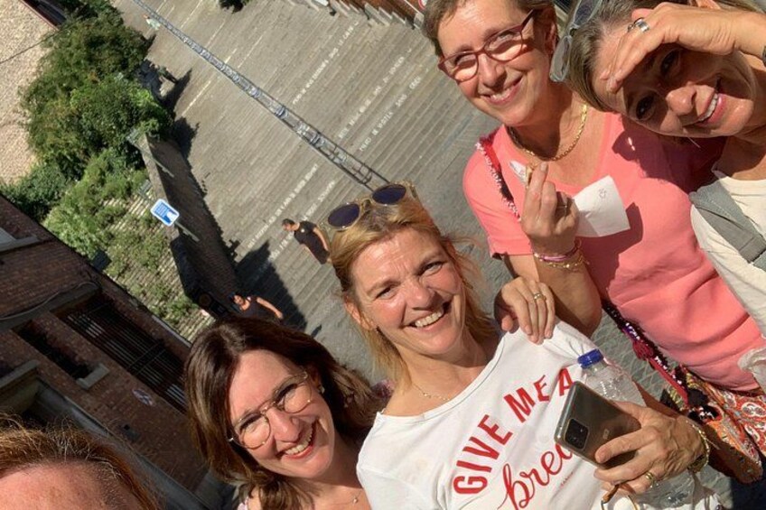 Un groupe de personnes se tient sur un toit, avec une vue sur la ville en arrière-plan. 3