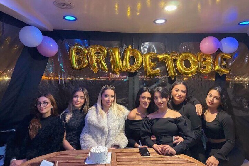 Un gruppo di persone a una festa con un cartello 'BRIDE DETOBE' e palloncini. 2
