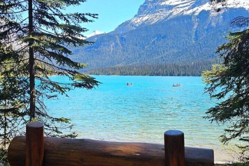 Un lago con barcos, rodeado de montañas y árboles. 3