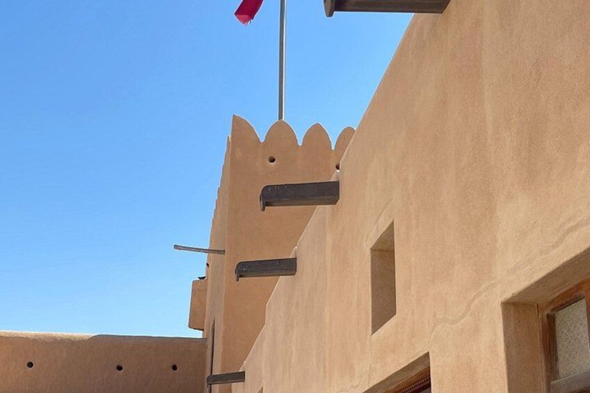 A building with a flat roof and a red flag on a pole. 3