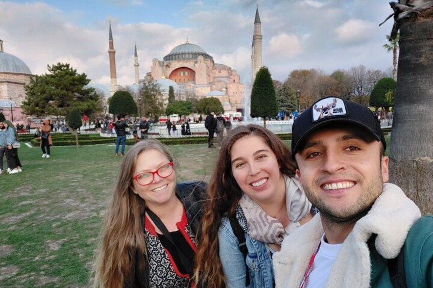 A group of people in a park with historical buildings in the background. 4