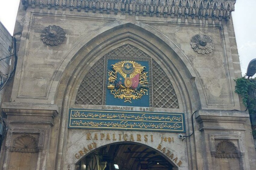 A stone archway with intricate carvings and a central emblem. 5