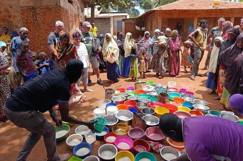 People gathered around a large collection of colorful bowls and containers, possibly for a communal activity. 4