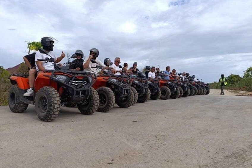 A group of people riding ATVs on a dirt road. 3