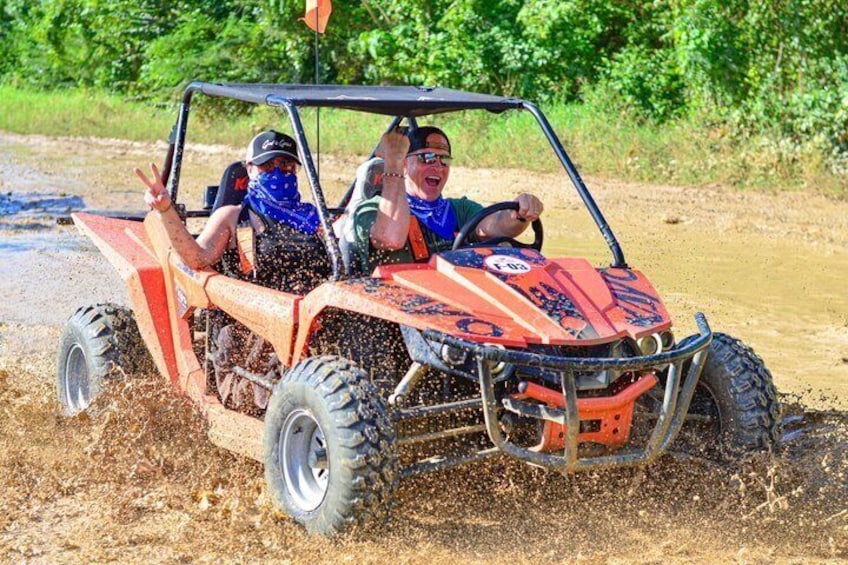 Un véhicule tout-terrain rouge traverse une zone boueuse. 1