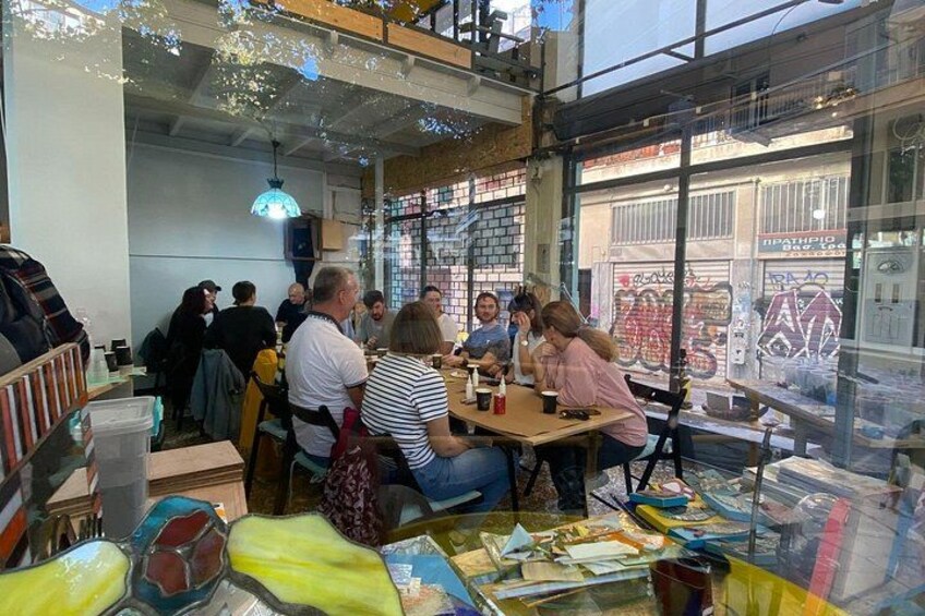 A group of people sitting at tables inside a cafe with large windows. 2
