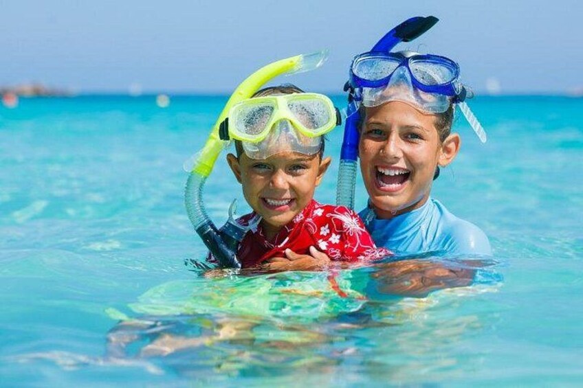 Twee mensen snorkelen in helderblauw water. 2