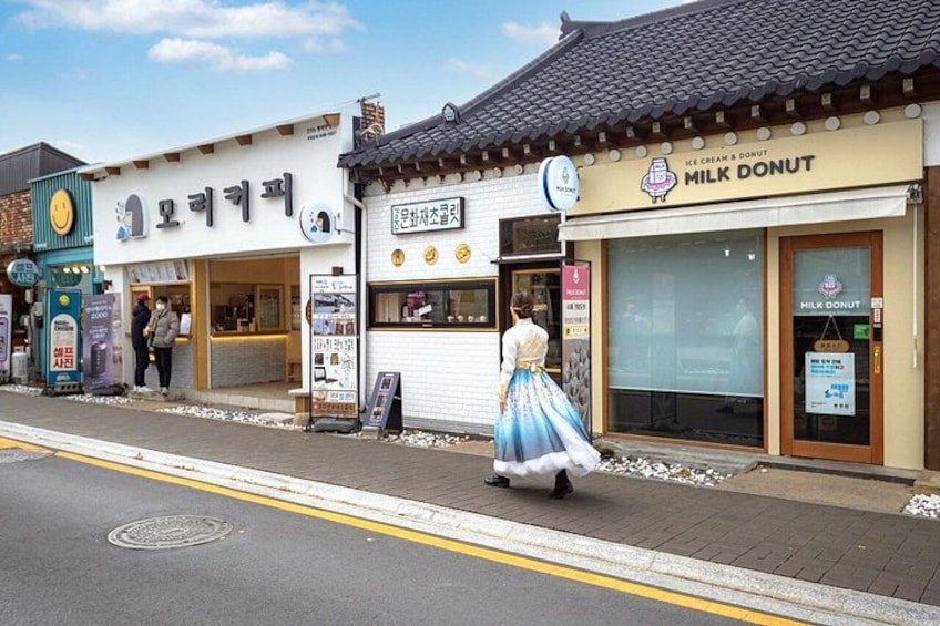 A street with shops, including a milk donut store and a bakery. 4